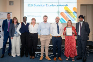 The highly commended poses for a group photo with their certificate and the Chair of the Authority, Sir Robert Chote